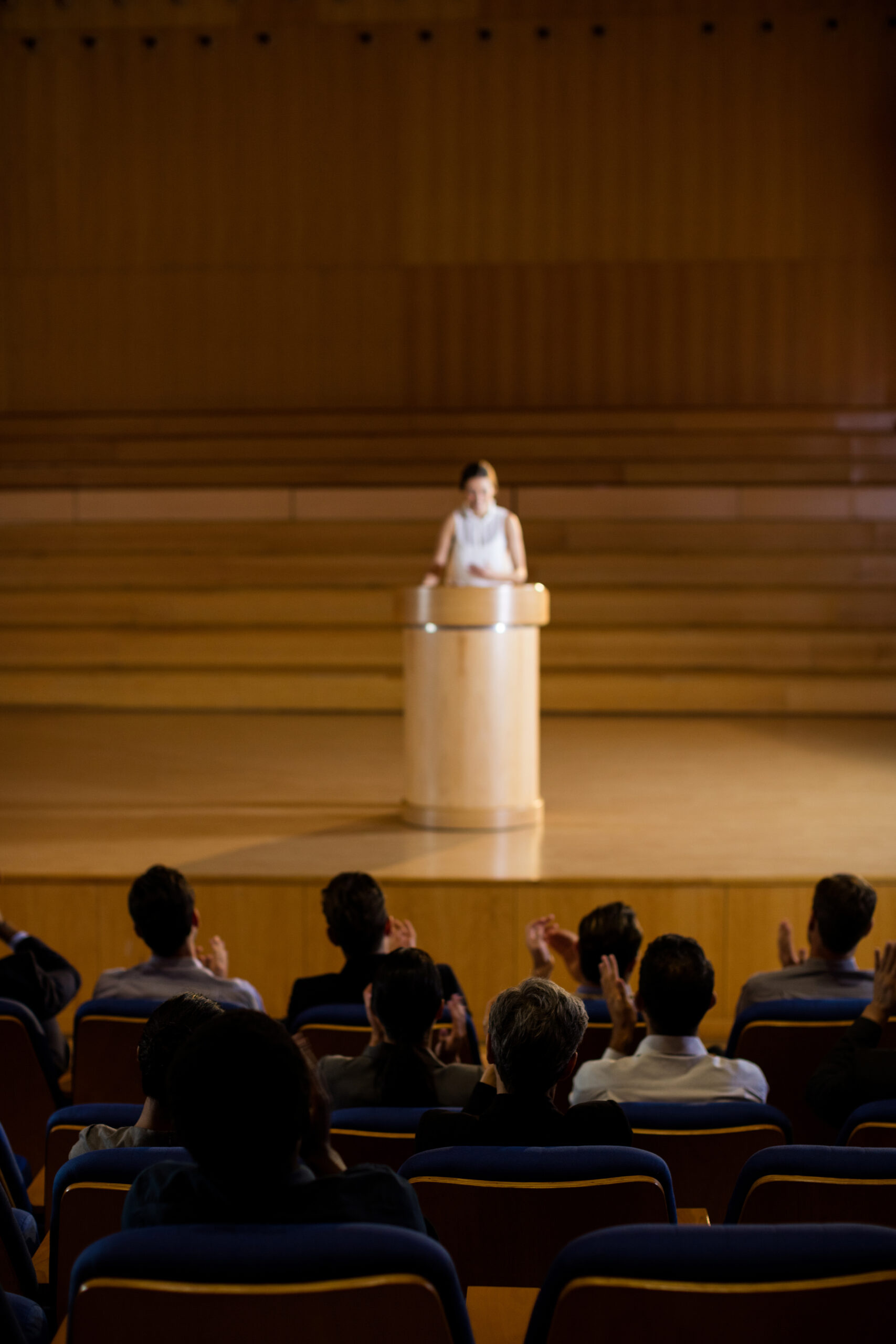 Audience applauding speaker after conference presentation at conference center